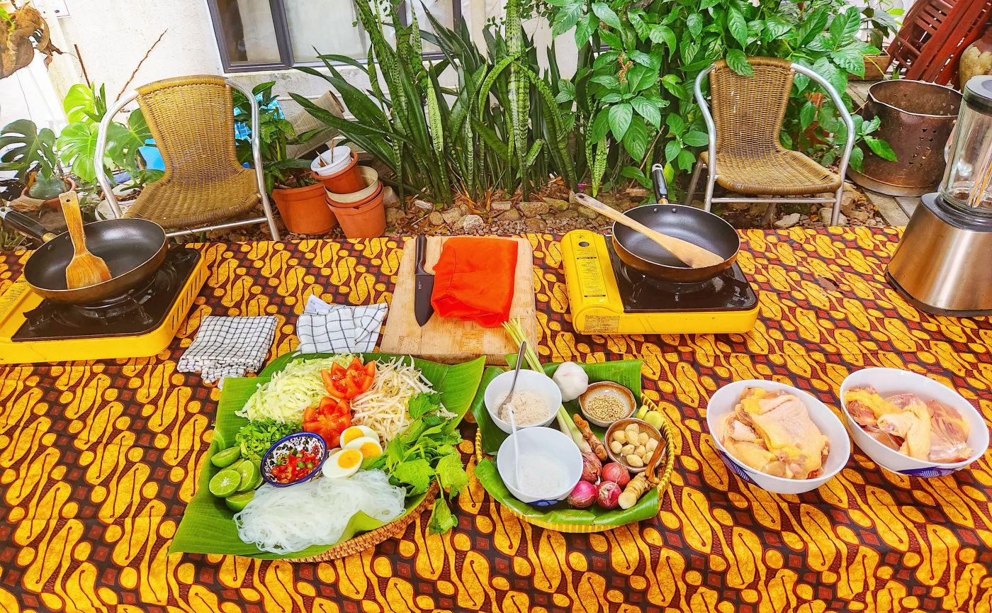 Fresh galangal, candlenuts, shallots, lemongrass and spices on banana leaf over a traditional batik-print tablecloth