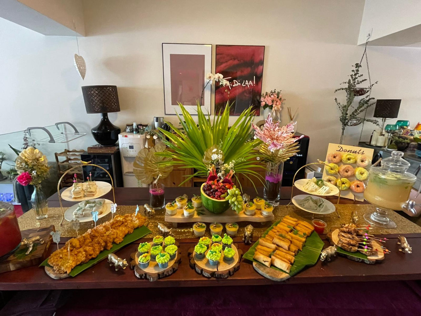 Festive party buffet with satay skewers, spring rolls and desserts styled on banana leaf